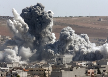 Thick smoke from an airstrike by the US-led coalition rises in Kobani, Syria, as seen from a hilltop on the outskirts of Suruc, at the Turkey-Syria border, Wednesday, Oct. 22, 2014. Kobani, also known as Ayn Arab, and its surrounding areas, has been under assault by extremists of the Islamic State group since mid-September and is being defended by Kurdish fighters. (AP Photo/Lefteris Pitarakis)