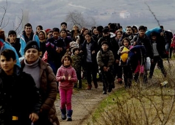 Refugees and migrants, mostly from Afghanistan, walk towards the transit center for refugees near the northern Macedonian village of Tabanovce, after being returned from Serbia, Monday, Feb. 22, 2016. Hundreds of Afghan refugees were stranded since Saturday at the transit center in Tabanovce in northern Macedonia. Serbia says the decision to block refugees from Afghanistan from passing through the so-called Balkan migrant corridor has been made by Austria and Slovenia. (AP Photo/Boris Grdanoski)
