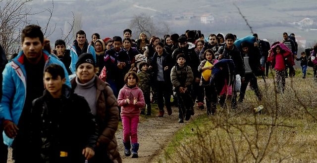 Refugees and migrants, mostly from Afghanistan, walk towards the transit center for refugees near the northern Macedonian village of Tabanovce, after being returned from Serbia, Monday, Feb. 22, 2016. Hundreds of Afghan refugees were stranded since Saturday at the transit center in Tabanovce in northern Macedonia. Serbia says the decision to block refugees from Afghanistan from passing through the so-called Balkan migrant corridor has been made by Austria and Slovenia. (AP Photo/Boris Grdanoski)