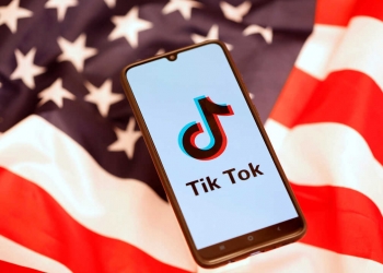 Tik Tok logo is displayed on the smartphone while standing on the U.S. flag in this illustration picture taken, November 8, 2019. REUTERS/Dado Ruvic