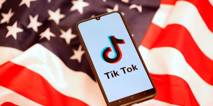 Tik Tok logo is displayed on the smartphone while standing on the U.S. flag in this illustration picture taken, November 8, 2019. REUTERS/Dado Ruvic