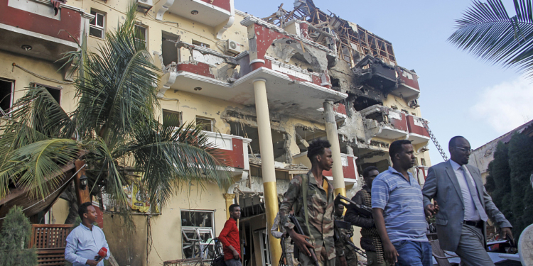 Security forces and others walk in front of the damaged Hayat Hotel in the capital Mogadishu, Somalia Sunday, Aug. 21, 2022. Somali authorities on Sunday ended a deadly attack in which at least 20 people were killed and many others wounded when gunmen from the Islamic extremist group al-Shabab, which has ties with al-Qaida, stormed the Hayat Hotel in the capital on Friday evening. (AP Photo/Farah Abdi Warsameh)