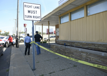 Detroit Police and investigators look over a homicide scene on Wyoming Avenue, near the corner of Seven Mile Road, Sunday, Aug. 28, 2022, in Detroit. Four people were shot, with fatalities, by a person who appeared to be firing at people randomly over a roughly 2 1/2-hour period Sunday morning in Detroit, police said. (Jose Juarez/Special to Detroit News via AP)