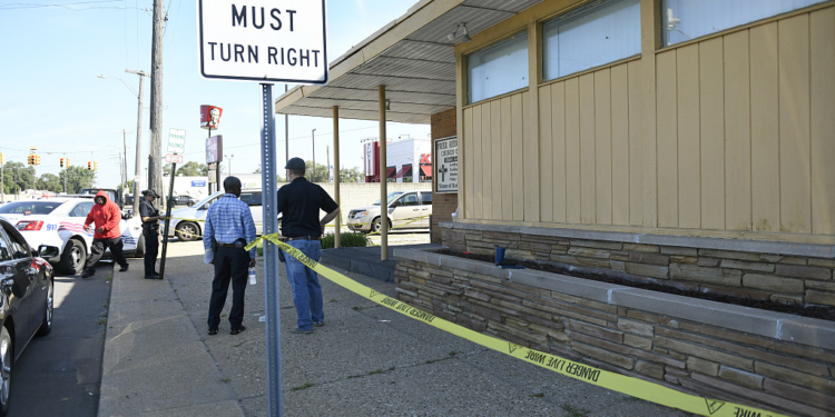 Detroit Police and investigators look over a homicide scene on Wyoming Avenue, near the corner of Seven Mile Road, Sunday, Aug. 28, 2022, in Detroit. Four people were shot, with fatalities, by a person who appeared to be firing at people randomly over a roughly 2 1/2-hour period Sunday morning in Detroit, police said. (Jose Juarez/Special to Detroit News via AP)