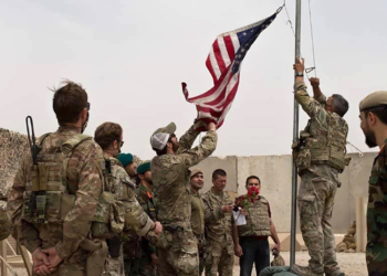 A U.S. flag is lowered as American and Afghan soldiers attend a handover ceremony from the U.S. Army to the Afghan National Army, at Camp Anthonic, in Helmand province, southern Afghanistan, Sunday, May 2, 2021. (Afghan Ministry of Defense Press Office via AP)