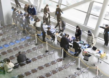 Travelers and visitors from mainland China take quantitative antigen tests on their arrival at the quarantine booth of Kansai Airport in Izumi-Sano, Osaka Prefecture on 10, 2023. the  Japanese government ramps up its COVID-19 border controls for those arriving from mainland China via direct flights, requiring them to submit certificates of negative test results for the coronavirus within 72 hours of departure. ( The Yomiuri Shimbun via AP Images )