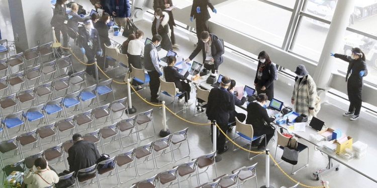 Travelers and visitors from mainland China take quantitative antigen tests on their arrival at the quarantine booth of Kansai Airport in Izumi-Sano, Osaka Prefecture on 10, 2023. the  Japanese government ramps up its COVID-19 border controls for those arriving from mainland China via direct flights, requiring them to submit certificates of negative test results for the coronavirus within 72 hours of departure. ( The Yomiuri Shimbun via AP Images )