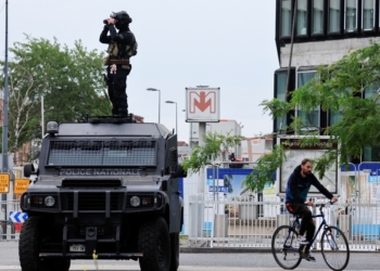 A French Recherche Assistance Intervention Dissuasion (RAID) special police unit member stands on his armoured car and uses his binoculars to check a protest following the death of Nahel, a 17-year-old teenager killed by a French police officer in Nanterre during a traffic stop, in Lille, France, 30 June 2023. REUTERS/Pascal Rossignol