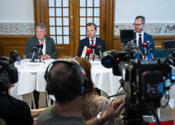 From left, Minister of Foreign Affairs Lars Loekke Rasmussen, Minister of Justice Peter Hummelgaard and Deputy Prime Minister Jakob Ellemann-Jensen present a bill on a Quran burning ban on a doorstep in Christiansborg, Copenhagen, Friday, Aug. 25, 2023. (Martin Sylvest/Ritzau Scanpix via AP)