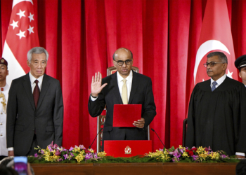 President Tharman Shanmugaratnam, flanked by Prime Minister Lee Hsien Loong (left) and Chief Justice Sundaresh Menon, taking his oath at the presidential inauguration at the Istana, 14 September 2023. President Tharman won the presidential election held on 1 September to become Singapore's ninth president. (Singapore Press via AP Images)