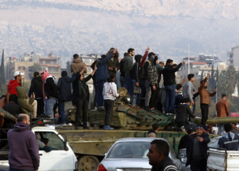 Syrians flash victory signs as they celebrate the arrival of opposition fighters in Damascus, Syria, Sunday, Dec. 8, 2024. (AP Photo/Omar Sanadiki)