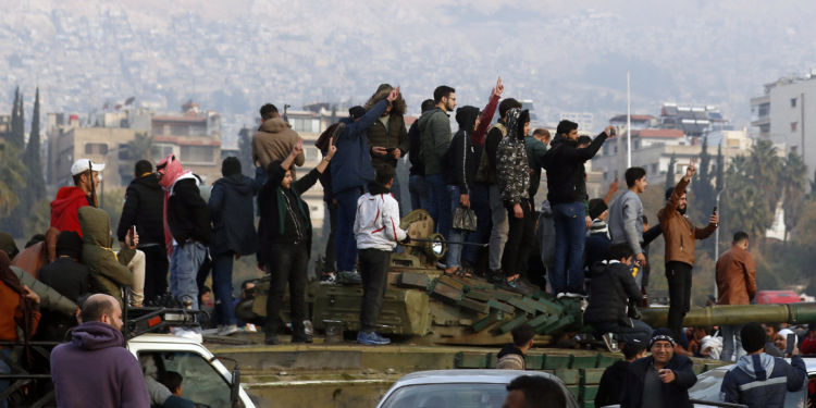 Syrians flash victory signs as they celebrate the arrival of opposition fighters in Damascus, Syria, Sunday, Dec. 8, 2024. (AP Photo/Omar Sanadiki)