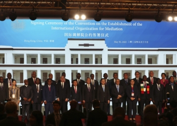 Chinese Foreign Minister Wang Yi, center, attends the signing ceremony of “the Convention on the Establishment of the International Organization for Mediation”, in Hong Kong, Friday, May 30, 2025. (AP Photo/Jonathan Lee)