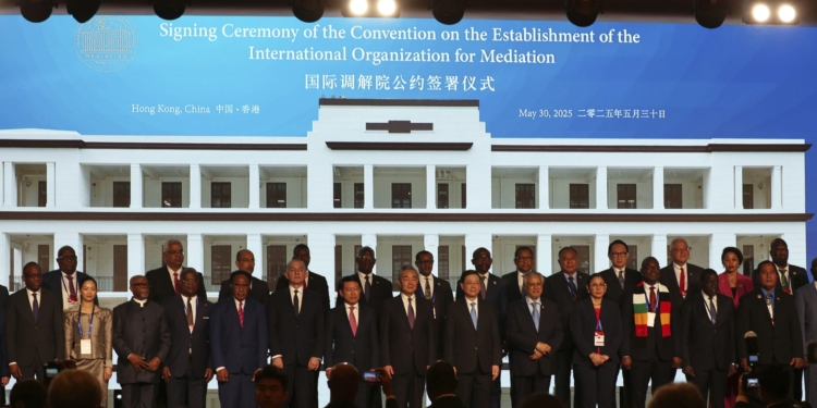 Chinese Foreign Minister Wang Yi, center, attends the signing ceremony of “the Convention on the Establishment of the International Organization for Mediation”, in Hong Kong, Friday, May 30, 2025. (AP Photo/Jonathan Lee)