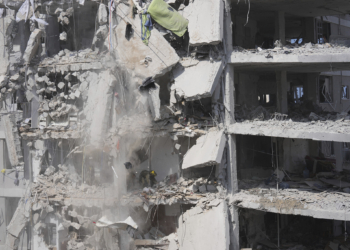 Concrete and rubble fall from a heavily damaged building as Israeli soldiers search for survivors in a residential area hit by a missile fired from Iran, near Tel Aviv, Israel, Sunday, June 15, 2025.(AP Photo/Ariel Schalit)