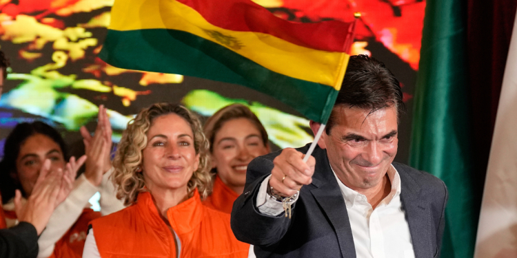 FILE - Presidential candidate Rodrigo Paz waves a Bolivian flag after preliminary results showed him leading in the presidential runoff election in La Paz, Bolivia, Oct. 19, 2025. (AP Photo/Natacha Pisarenko, File)