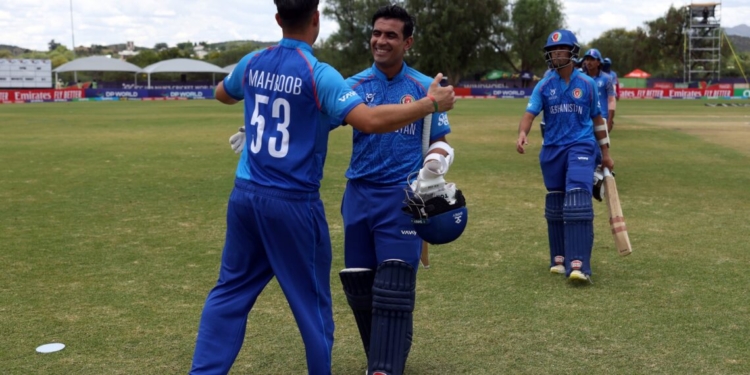 WINDHOEK, NAMIBIA - JANUARY 21: Faisal Khan of Afghanistan celebrates victory with teammate Mahboob Khan after the ICC U19 Men's Cricket World Cup 2026 match between Afghanistan and Tanzania at HP Oval on January 21, 2026 in Windhoek, Namibia. (Photo by Matthew Lewis-ICC/ICC via Getty Images)