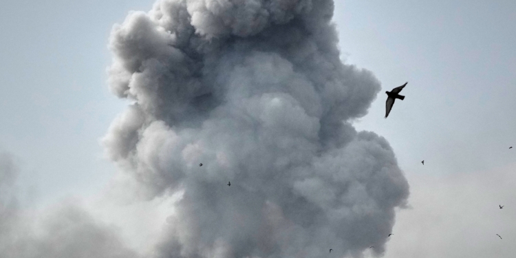 A bird flies by a plume of smoke rising after a strike in Tehran, Iran, Monday, March 2, 2026. (AP Photo/Vahid Salemi)