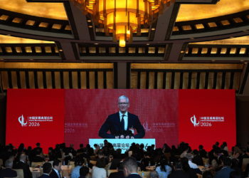 Apple CEO Tim Cook is seen on a big screen live broadcasting his speech at the opening of the China Development Forum 2026 held at the Diaoyutai State Guesthouse in Beijing on Sunday, March 22, 2026. (AP Photo/Ng Han Guan, Pool)
