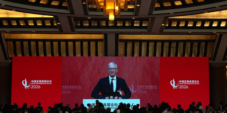 Apple CEO Tim Cook is seen on a big screen live broadcasting his speech at the opening of the China Development Forum 2026 held at the Diaoyutai State Guesthouse in Beijing on Sunday, March 22, 2026. (AP Photo/Ng Han Guan, Pool)