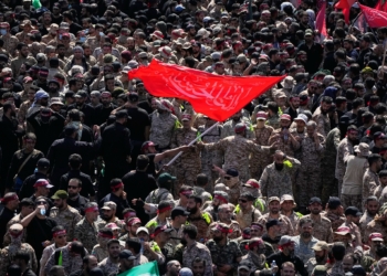 Uniformed members of the Islamic Revolutionary Guard Corps wave a Shiite religious flag during the funeral procession of the slain Iranian Supreme Leader Ayatollah Ali Khamenei and members of his family in Tehran, Iran, Monday, July 6, 2026. (AP Photo/Vahid Salemi)