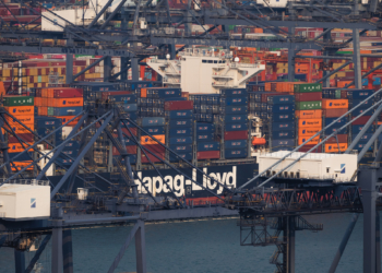 SHENZHEN, CHINA - APRIL 15: A Hapag-Lloyd container vessel is seen docked among gantry cranes and stacked shipping containers at Yantian International Container Terminals on April 15, 2026 in Shenzhen, Guangdong province, China. Hapag-Lloyd is one of the world’s major container shipping companies, and operations at Chinese ports such as Yantian highlight the scale of global trade and maritime logistics networks. (Photo by Cheng Xin/Getty Images)