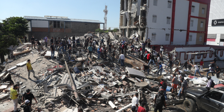 Residents and rescue workers search through the rubble of a collapsed building after an earthquake struck Cali, Colombia, Monday, Aug. 10, 2026. (AP Photo/Santiago Saldarriaga)