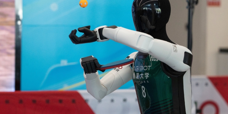 A humanoid robot serves as it plays table tennis with a human during a media preview, ahead of the World Humanoid Robotic Games in Beijing, China, Friday, Aug. 14, 2026. (Andres Martinez Casares/Pool Photo via AP)