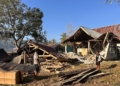 People stand near earthquake-damaged buildings in Satar Punda, East Nusa Tenggara province, Indonesia, Tuesday, Aug. 18, 2026. (AP Photo/Firdia Lisnawati)
