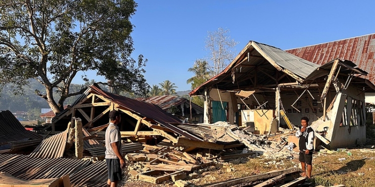 People stand near earthquake-damaged buildings in Satar Punda, East Nusa Tenggara province, Indonesia, Tuesday, Aug. 18, 2026. (AP Photo/Firdia Lisnawati)