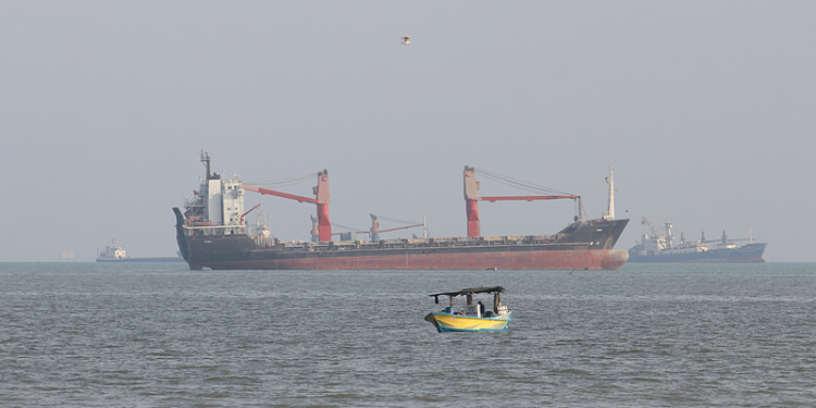 A boat floats as commercial vessels appear anchored in the Strait of Hormuz off Bandar Abbas, Iran, Tuesday, Oct. 13, 2026. (Razieh Poudat/ISNA via AP)